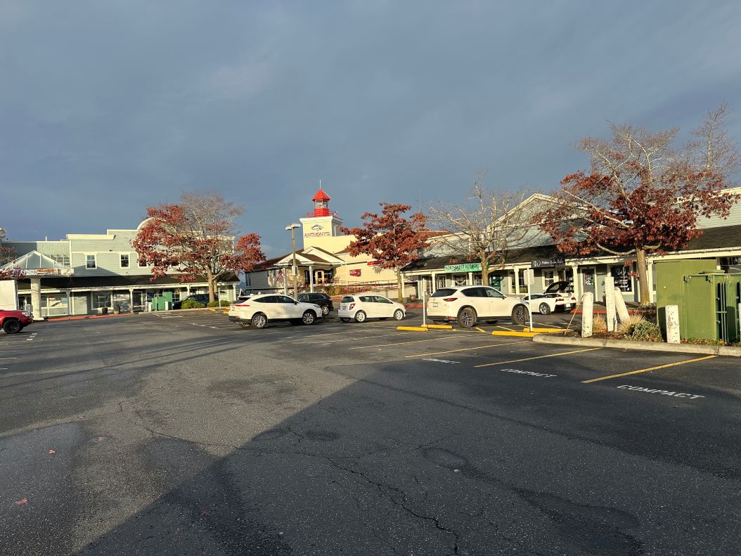 View of the Anthony’s Everett Marina building and parking area with fall-colored trees and parked cars.